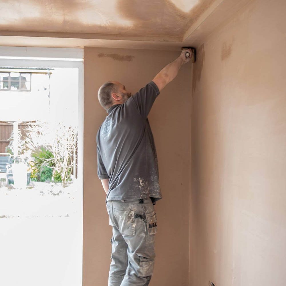 Plasterer finishing the corners of a wall